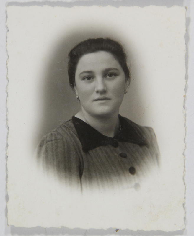 Retrato de estudio en plano medio de una mujer joven con el cabello recogido y pendientes pequeños. Viste una prenda con patrón de rayas finas, caracterizada por un cuello oscuro de textura aterciopelada y tres botones grandes visibles. La pose es frontal con un ligero giro, capturada con un efecto de viñeta suave común en la fotografía social de la época.