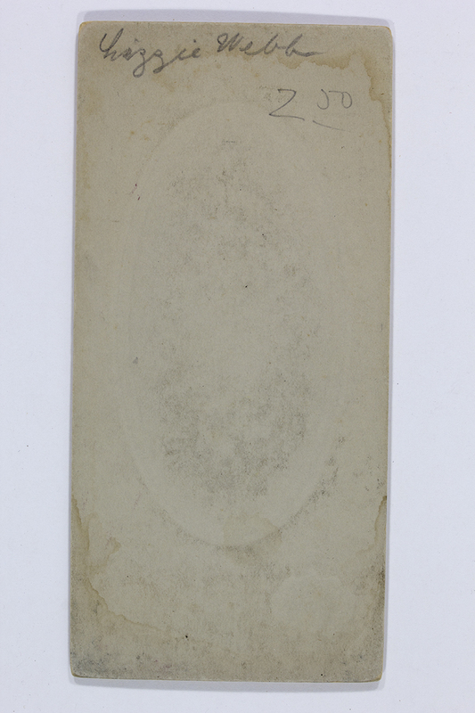 Vista posterior de un soporte fotográfico rígido de finales del siglo XIX. Presenta una inscripción manuscrita en la parte superior que reza 'Lizzie Webb' y una cifra numérica '2 00' debajo. El cartón muestra signos evidentes de envejecimiento, con manchas de humedad periféricas y una sutil huella central ovalada proyectada desde el anverso.
