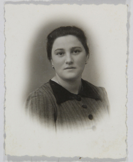 Retrato de estudio en plano medio de una mujer joven con el cabello recogido y pendientes pequeños. Viste una prenda con patrón de rayas finas, caracterizada por un cuello oscuro de textura aterciopelada y tres botones grandes visibles. La pose es frontal con un ligero giro, capturada con un efecto de viñeta suave común en la fotografía social de la época.