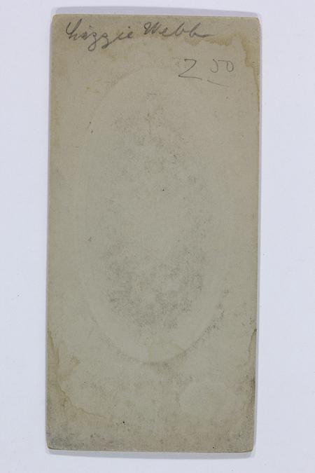 Vista posterior de un soporte fotográfico rígido de finales del siglo XIX. Presenta una inscripción manuscrita en la parte superior que reza 'Lizzie Webb' y una cifra numérica '2 00' debajo. El cartón muestra signos evidentes de envejecimiento, con manchas de humedad periféricas y una sutil huella central ovalada proyectada desde el anverso.
