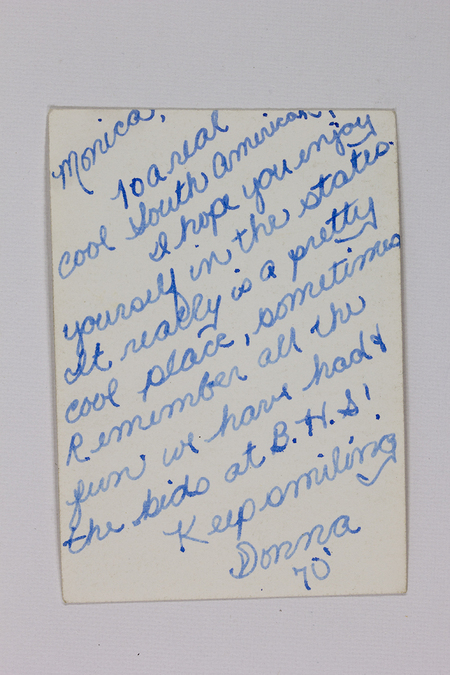 Reverso de una fotografía con un mensaje manuscrito en inglés fechado en 1970. Donna le escribe a Monica, refiriéndose a ella como una 'sudamericana' y expresando deseos de que disfrute su estancia en 'los Estados' (EE. UU.). Menciona recuerdos compartidos en una institución denominada 'B.H.S.', probablemente una escuela secundaria, y termina con una nota afectuosa.